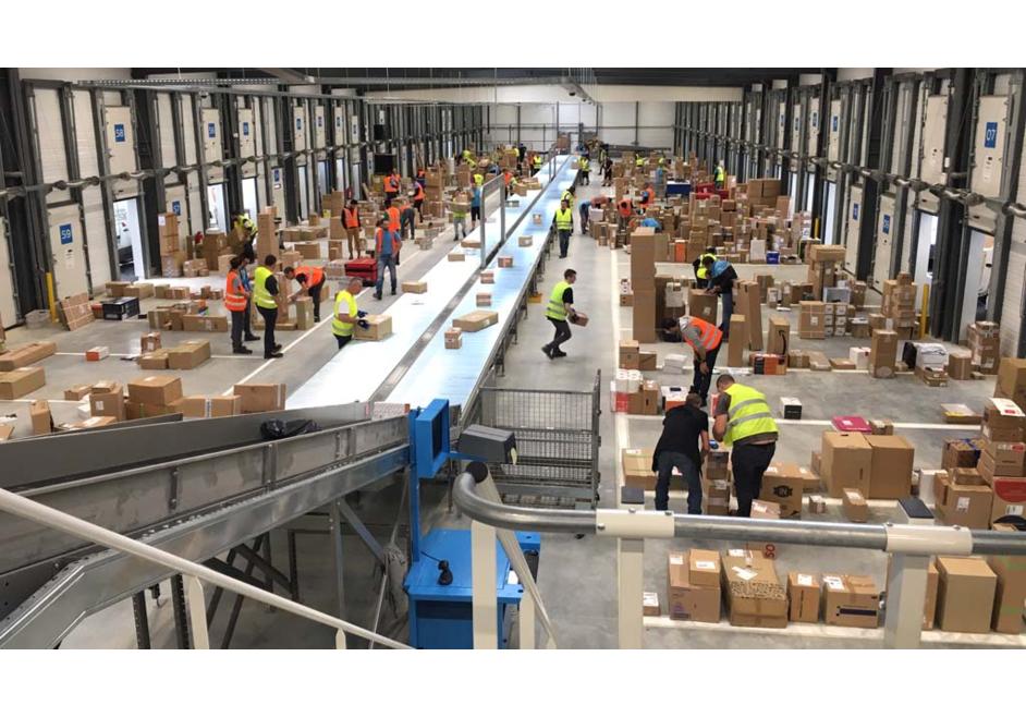 Plateforme logistique 3PL avec convoyeurs et opérateurs préparant, triant et expédiant des colis dans un centre de distribution.